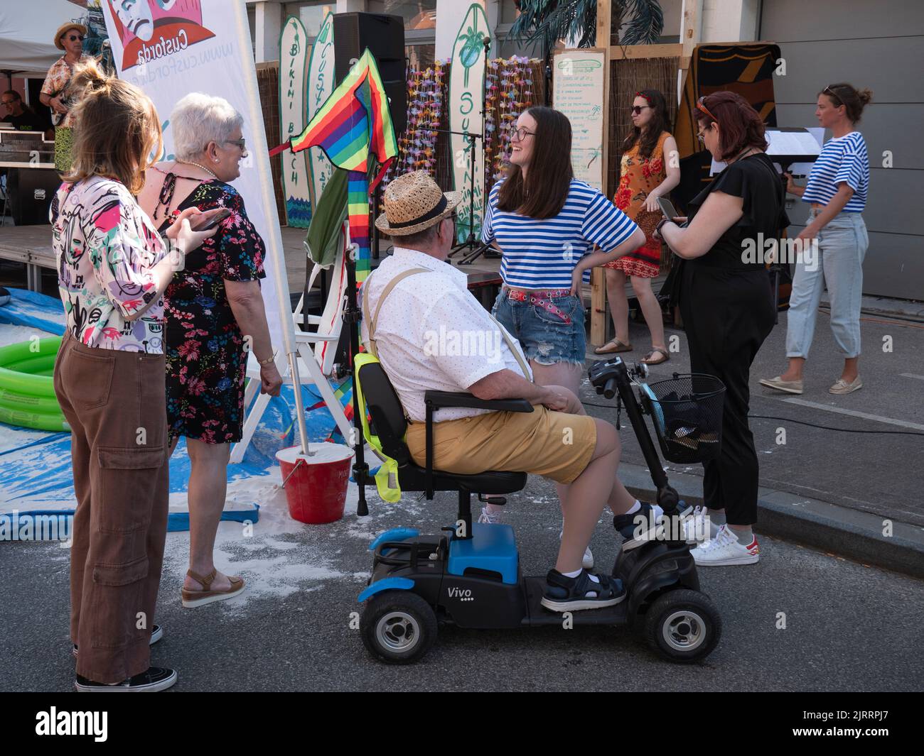 Sint Gillis Waas, Belgien, 06. August 2022, ein älterer Mann mit einem Mobilitätsroller hat ein Gespräch mit ein paar Damen Stockfoto