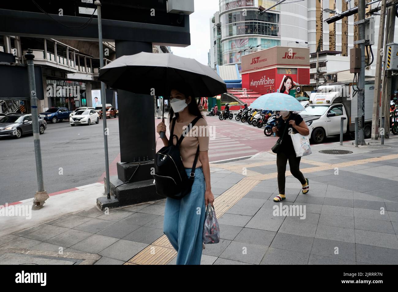 Ladies Walking down Soi Asoke aka Asok Montri Road aka Ratchadaphisek innere Ringstraße Bangkok Thailand in the Rain Stockfoto