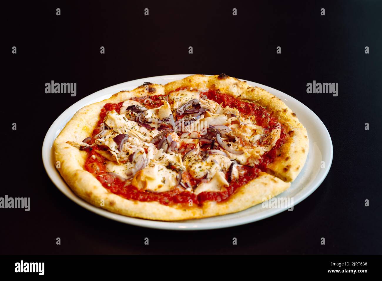 Schauen Sie sich frische Pizza mit Tomatensauce, Huhn und roten Zwiebeln an Stockfoto