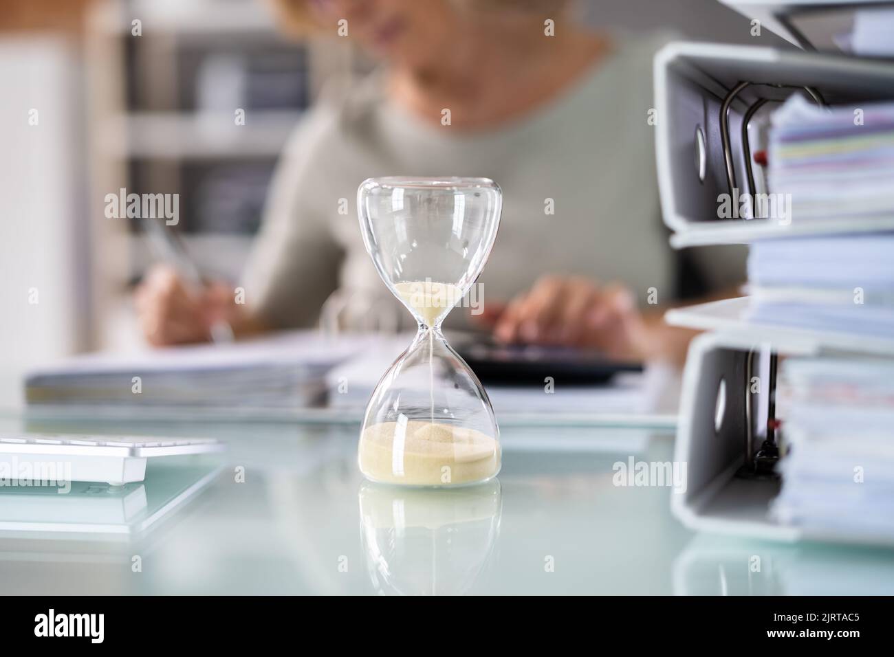 Verspätete Rechnung Und Rechnungsstellung Mit Hourglass Am Schreibtisch Stockfoto