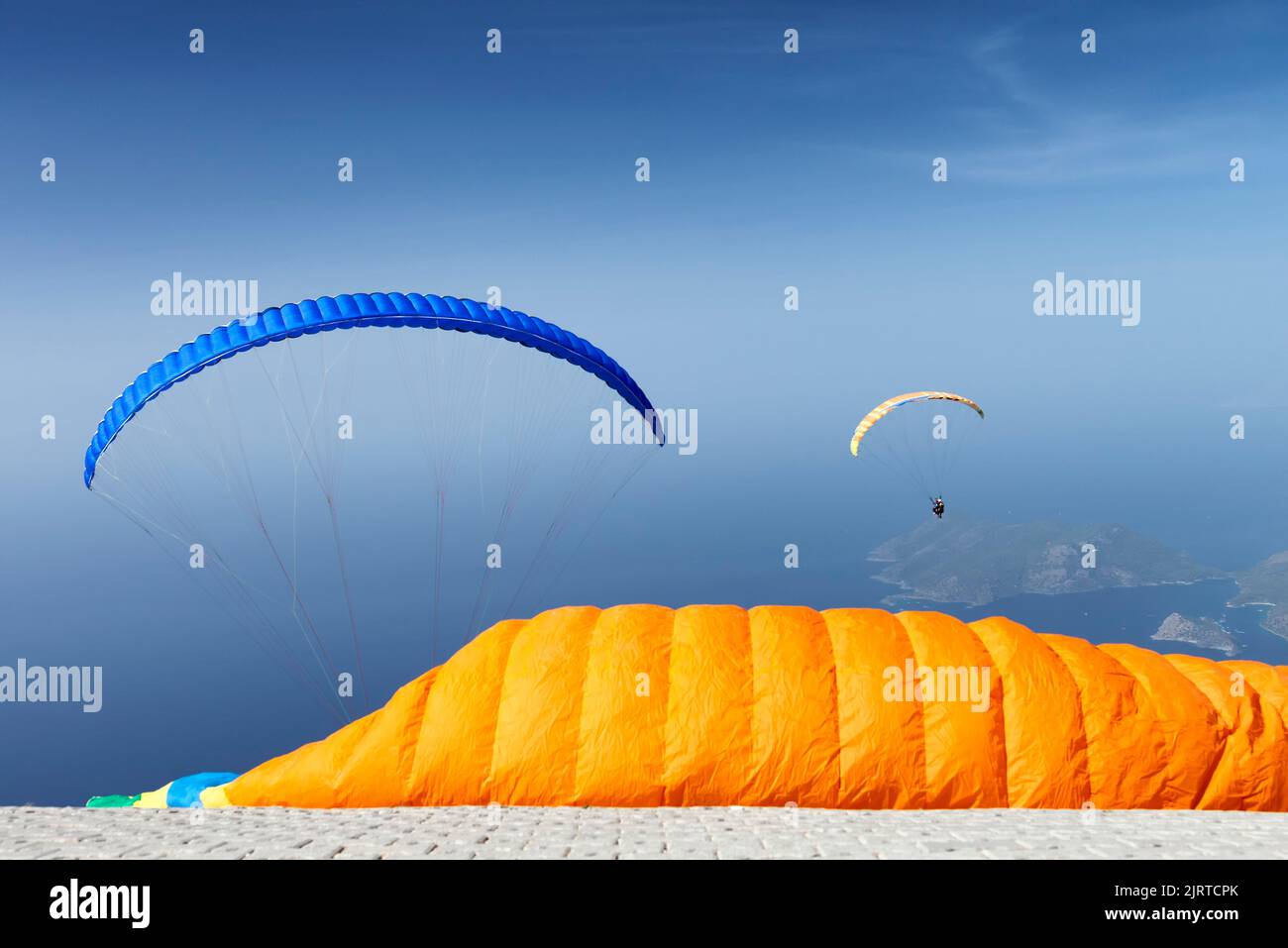 Gleitschirme im Flug mit Flügel an der Rampe im Vorgrund Stockfoto