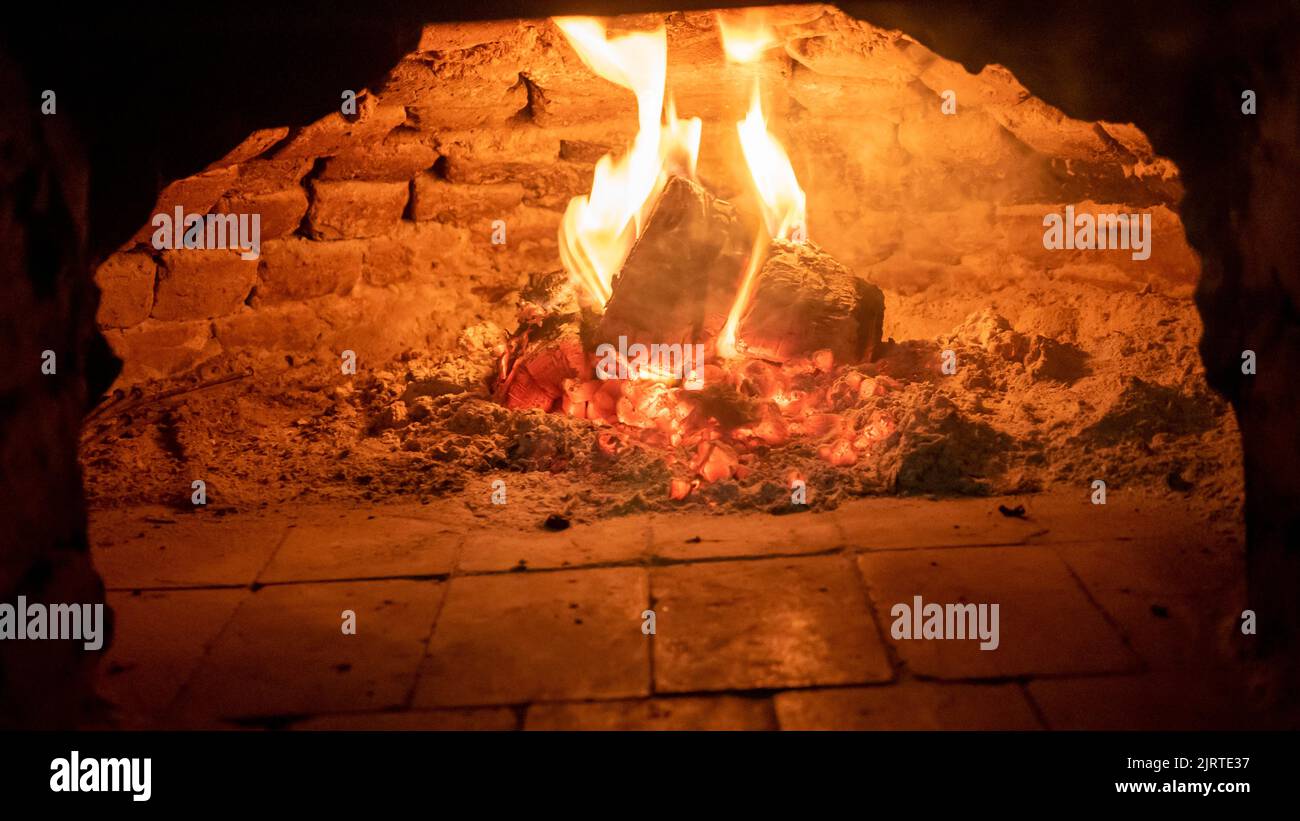 Holzofen. Feuerflammen, die im Ofen aufgehen. Holzofen im traditionellen Stil. Stockfoto