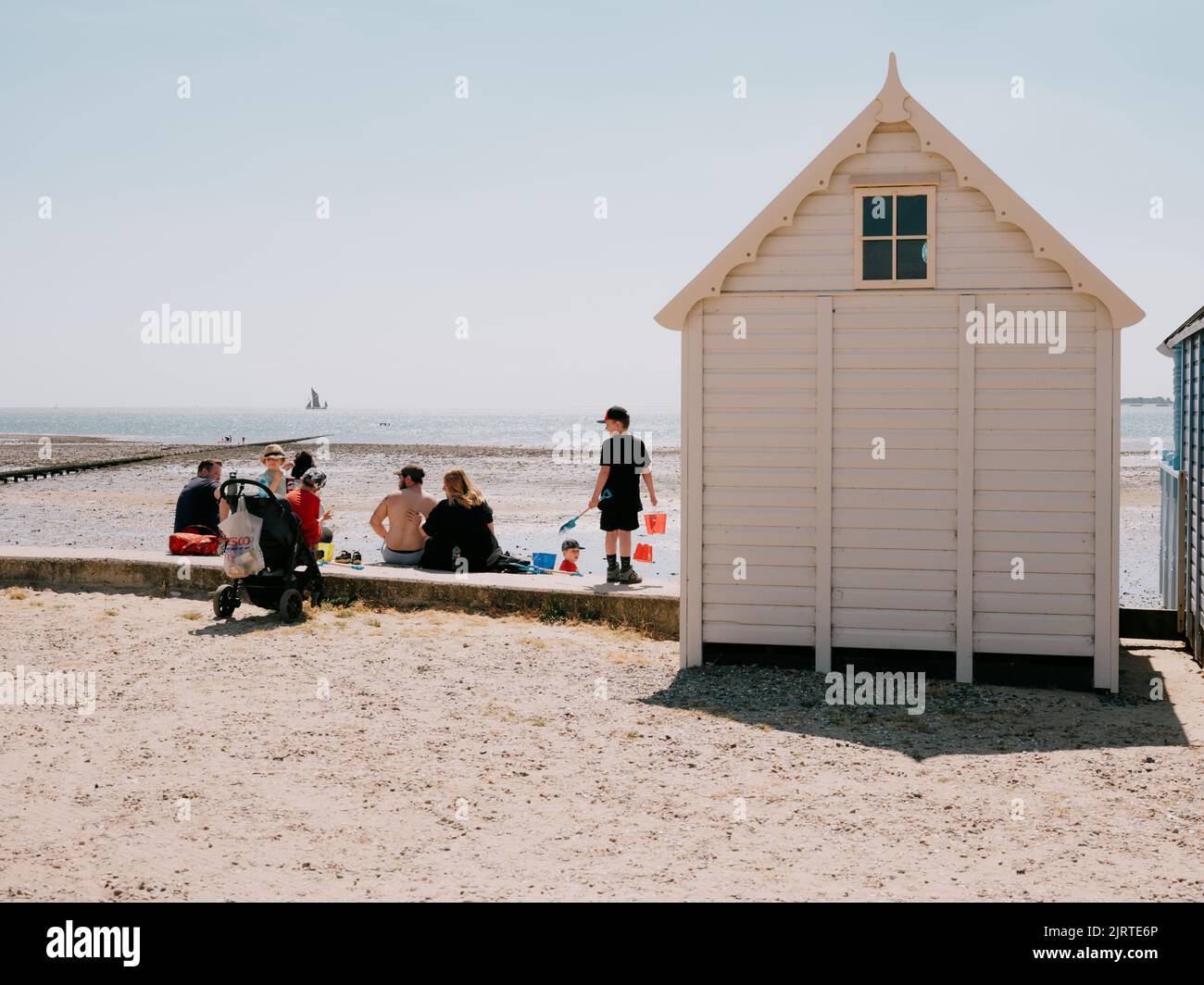 Eine Familie genießt einen Sommertag am Strand von West Mersea, Mersea Island, Essex, England - Aufenthalt Strandhütte Urlaub Stockfoto