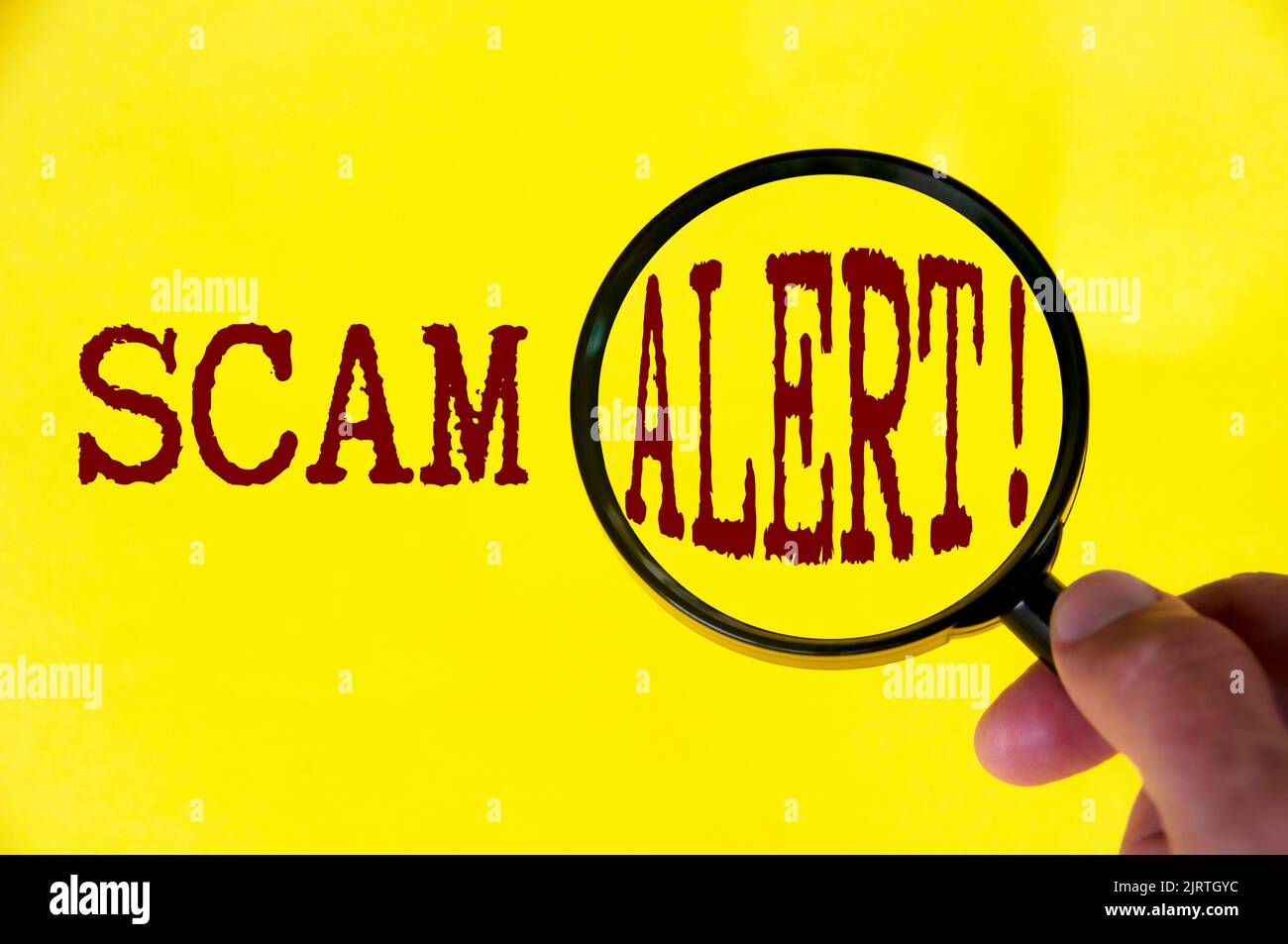Scam-Warntext auf gelbem Deckel mit Lupe. Konzept für Betrug und Betrug. Stockfoto