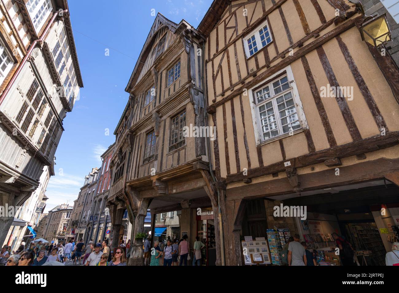 Touristenmassen, die eine Einkaufsstraße in der Innenstadt der mittelalterlichen Stadt Dinan, Bretagne, Frankreich, besuchen Stockfoto