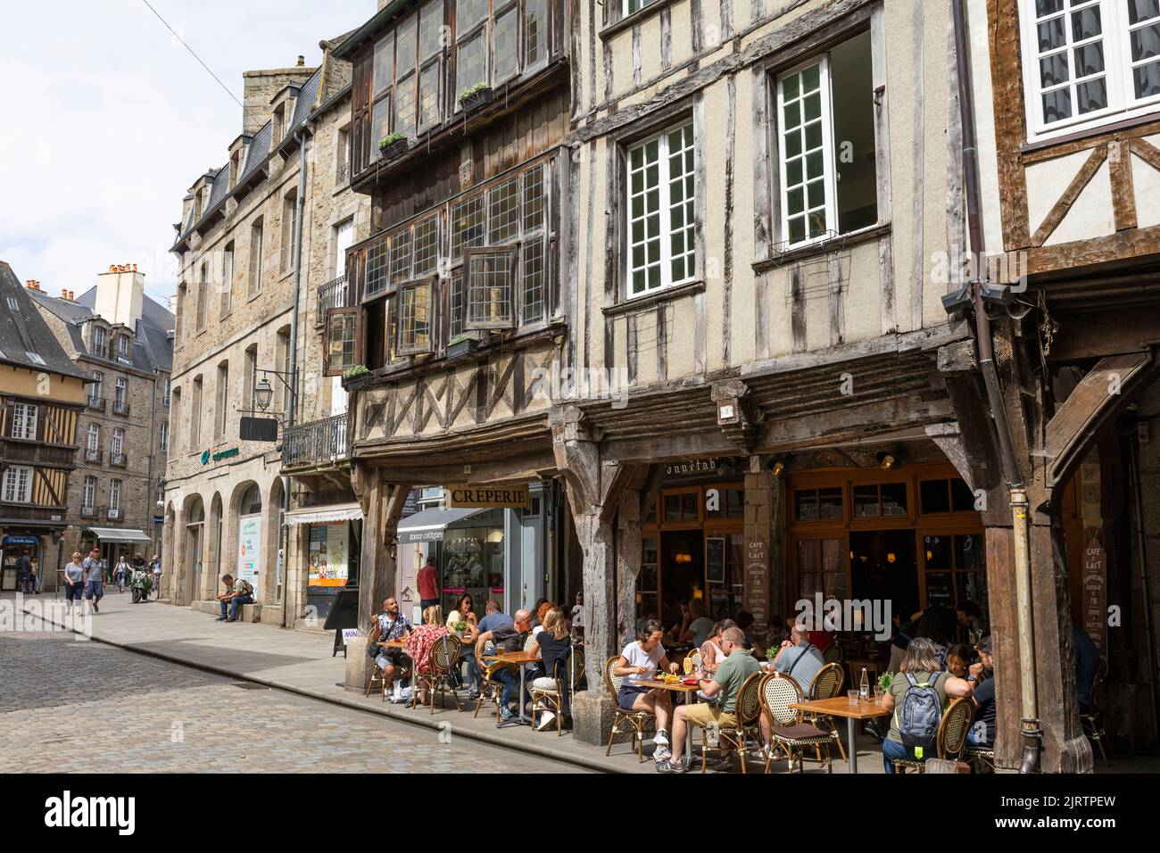 Touristen, die im Fachwerkrestaurant in der Innenstadt der mittelalterlichen Stadt Dinan, Bretagne, Frankreich, zu Mittag essen Stockfoto
