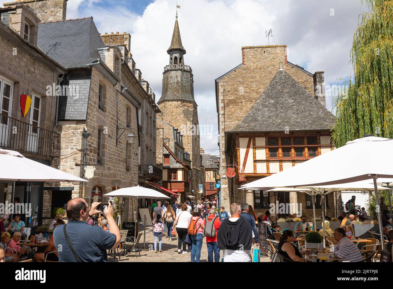 Touristenmassen zu Fuß in die Innenstadt der mittelalterlichen Stadt Dinan, Bretagne, Frankreich Stockfoto