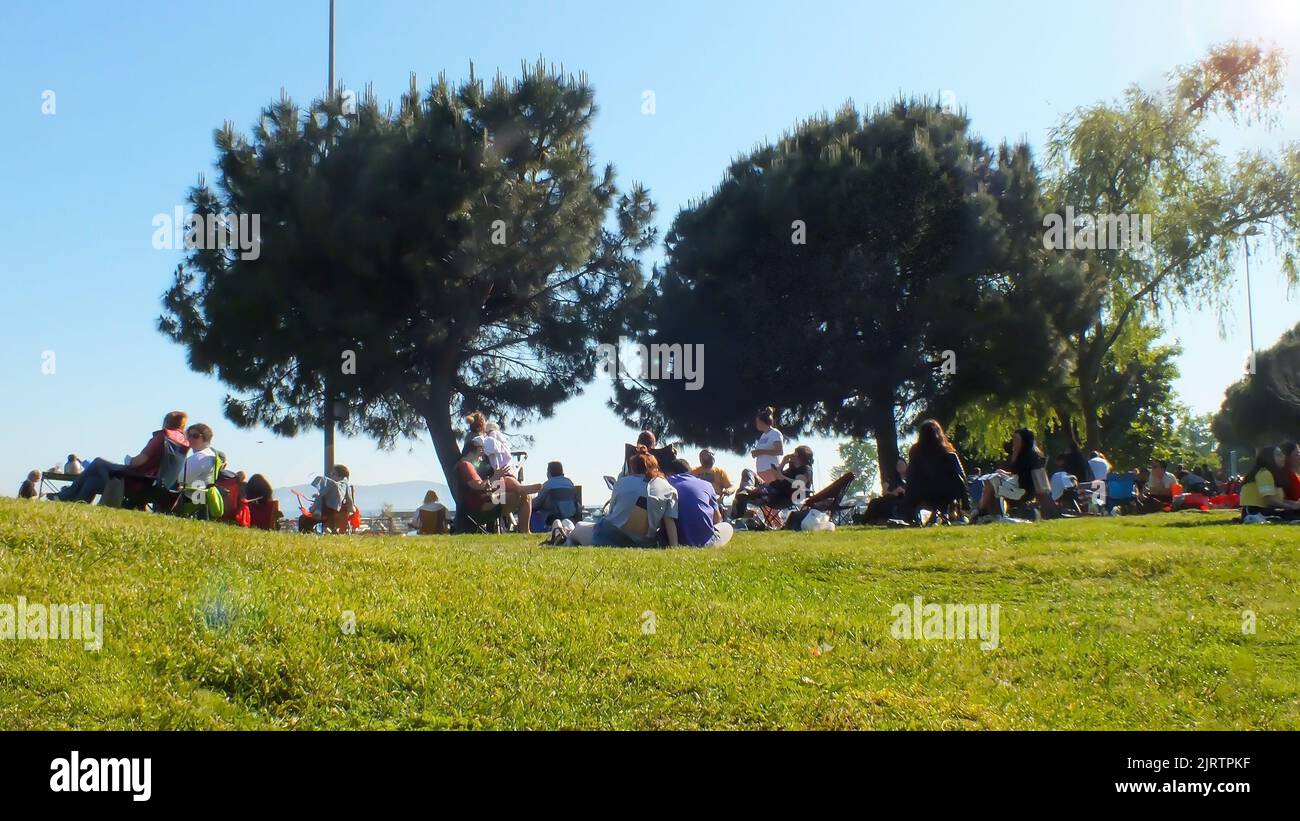 Leute picknicken auf dem Gras am Meer. Gruppe von Menschen, die auf Klappstühlen auf Gras sitzen. Istanbul, Türkei, Mai 21 2022 Stockfoto