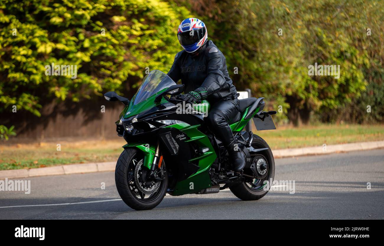 Mann in schwarzem Leder auf einer grünen Kawasaki Ninja H2 SX Stockfoto
