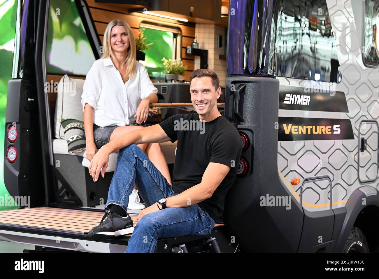 Düsseldorf, Deutschland. 26. August 2022. Die Modelle Daniel (r) und Anna sitzen in einem Venture S Offroader von Hymer. Die Leitmesse für Reisemobile und Caravans öffnet am 27. August ihre Pforten. Bis zum 4. September präsentieren 736 Aussteller aus 34 Ländern ihre Innovationen in Düsseldorf. Die Veranstalter erwarten rund 200.000 Besucher. Quelle: Federico Gambarini/dpa/Alamy Live News Stockfoto