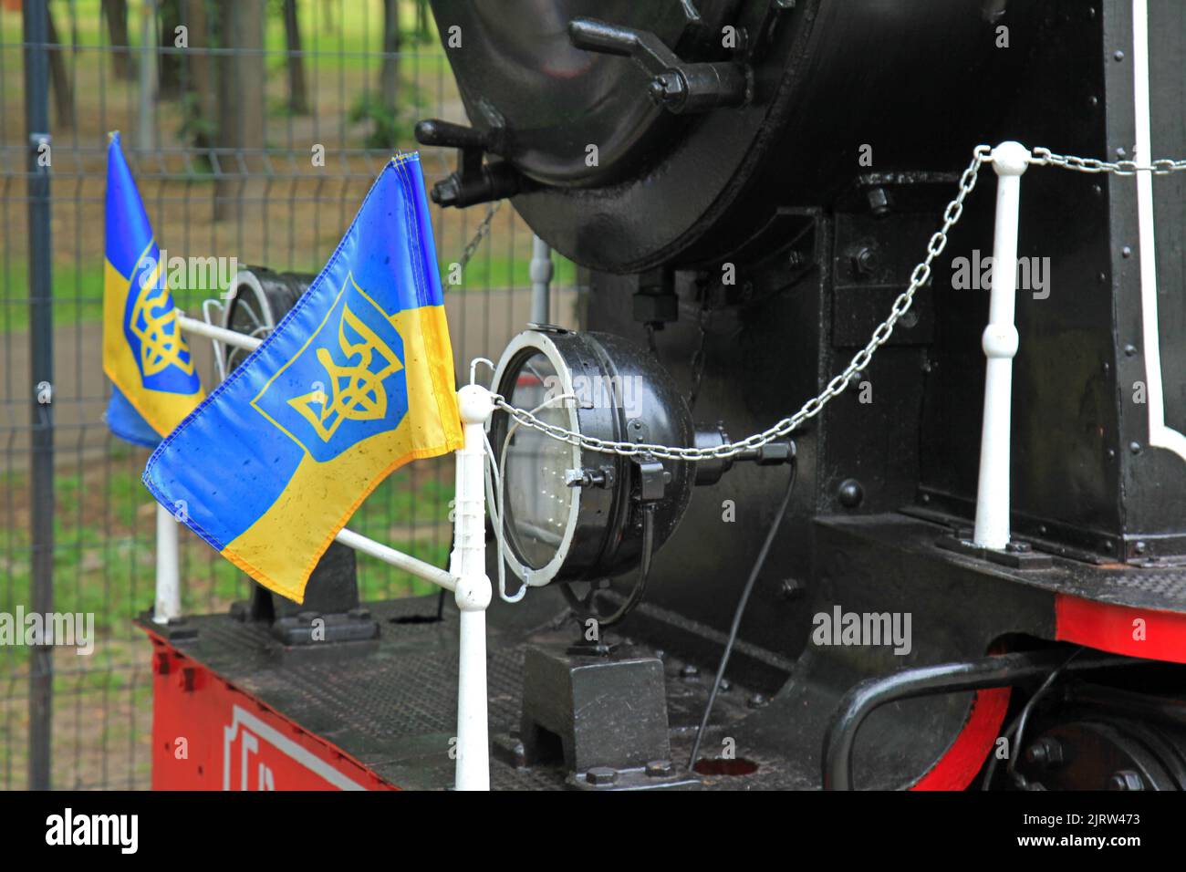 Kiew, Ukraine - 7. Juli 2012: Ukrainische Flaggen auf der Vorderseite der Schmalspurlokomotive. Eine alte, aber restaurierte Lokomotive auf der Kinderbahn Stockfoto