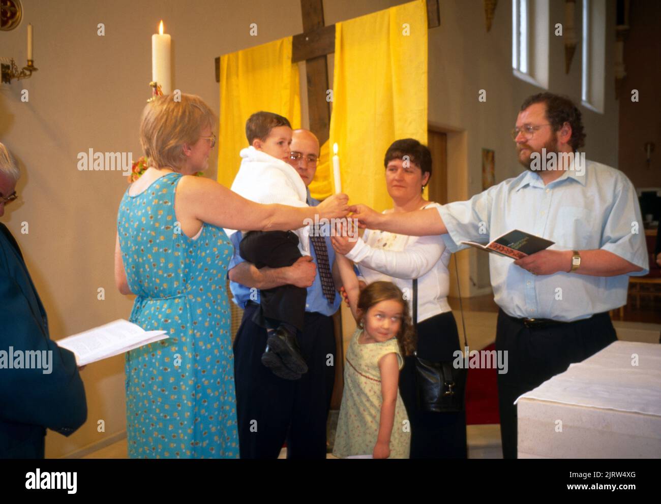 St. Joseph's Church Eltern und Paten halten die Osterkerze Roehampton Stockfoto