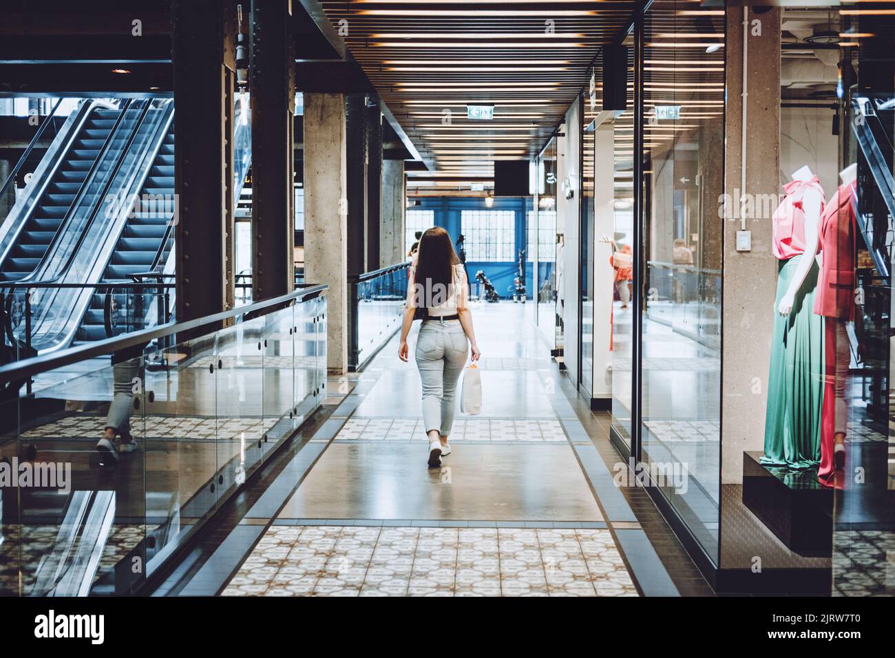 Moderne Latina junge Frau, die in einem großen modernen Einkaufszentrum läuft. Junge hübsche Brünette weibliche Verbraucher Stockfoto