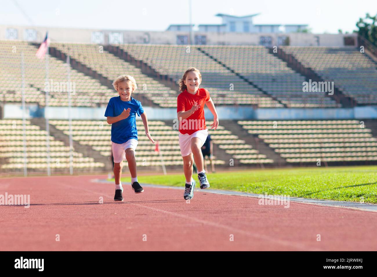 Kinder laufen im Stadion. Die Kinder laufen auf der Strecke im Freien. Gesunde sportliche