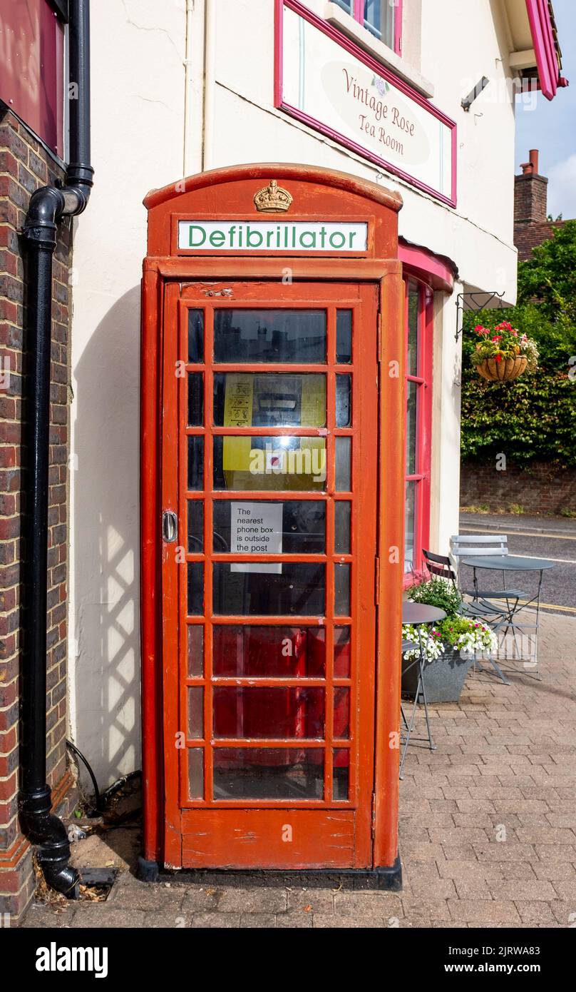 Umgebaute rote Telefonbox mit einem Herzdefibrillator-Gerät in Storrington, einer kleinen Stadt im Horsham District in West Sussex, England Stockfoto
