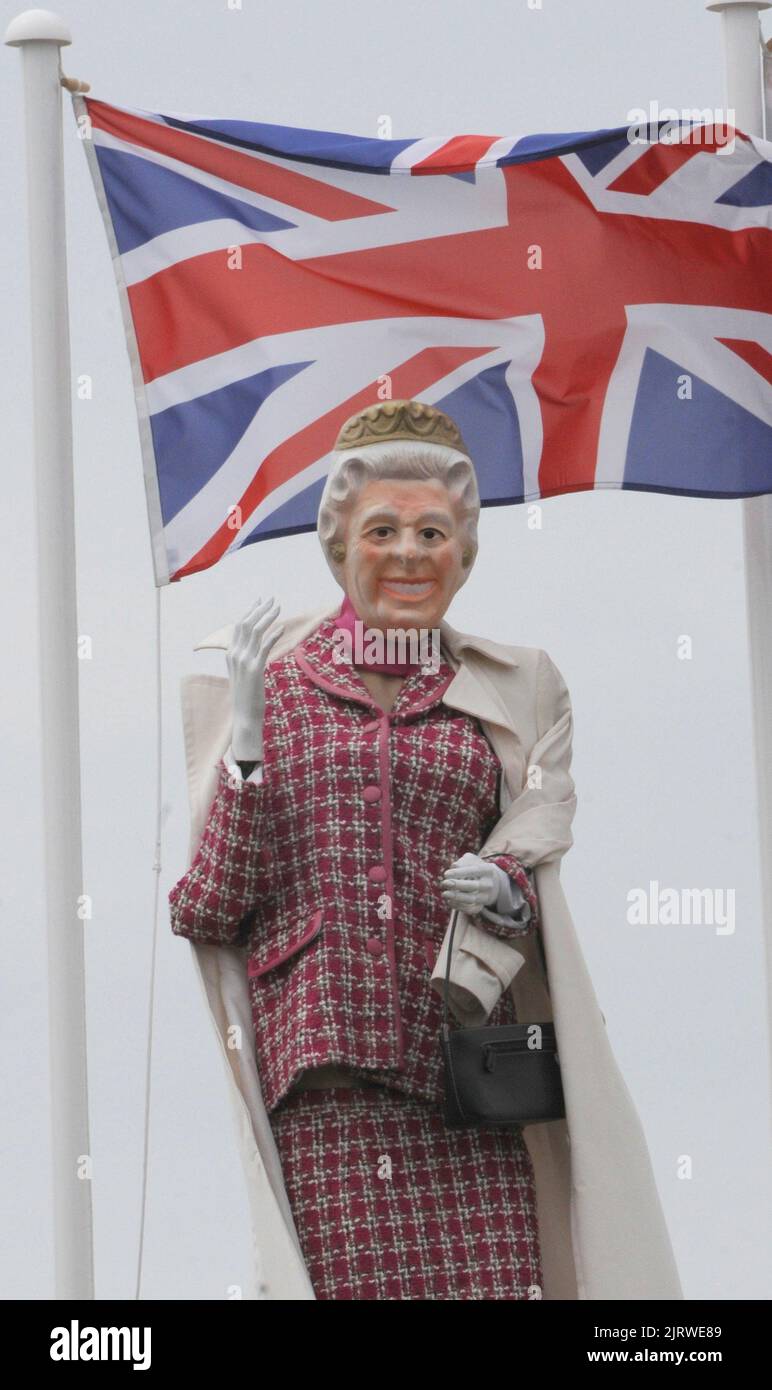 IHRE MAJESTÄT KÖNIGIN ELIZABETH ZUSAMMEN MIT CORGIS GIBT EINE KÖNIGLICHE WELLE AN VORBEIFAHRENDE AUTOFAHRER AUF DER A27 IN CHICHESTER VOM DACH EINES WERKZEUGVERLEIHS FIRMA . BILDER VON MIKE WALKER, MIKE WALKER, 2012 Stockfoto