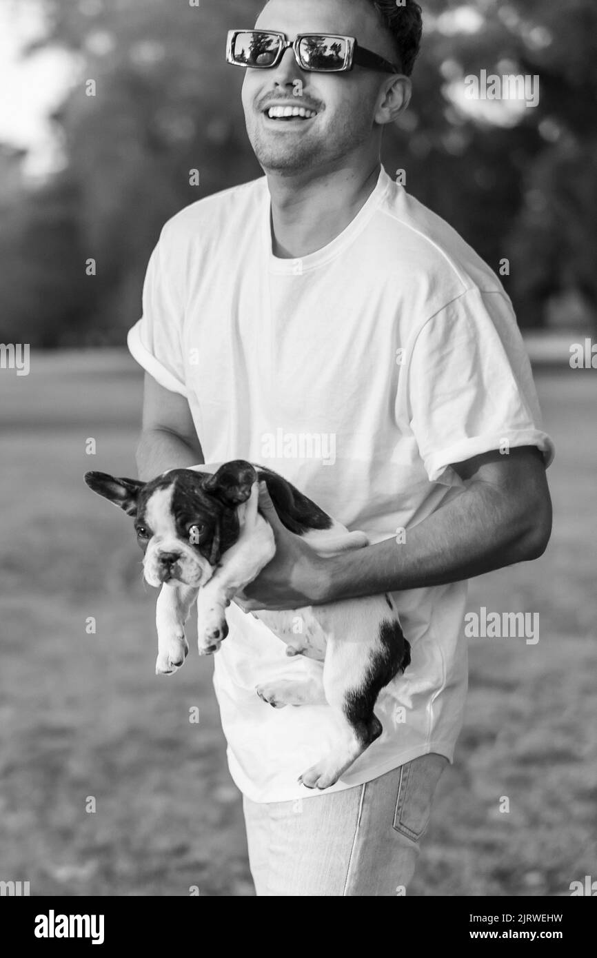 Hübscher junger Mann mit einer französischen Bulldogge Stockfoto