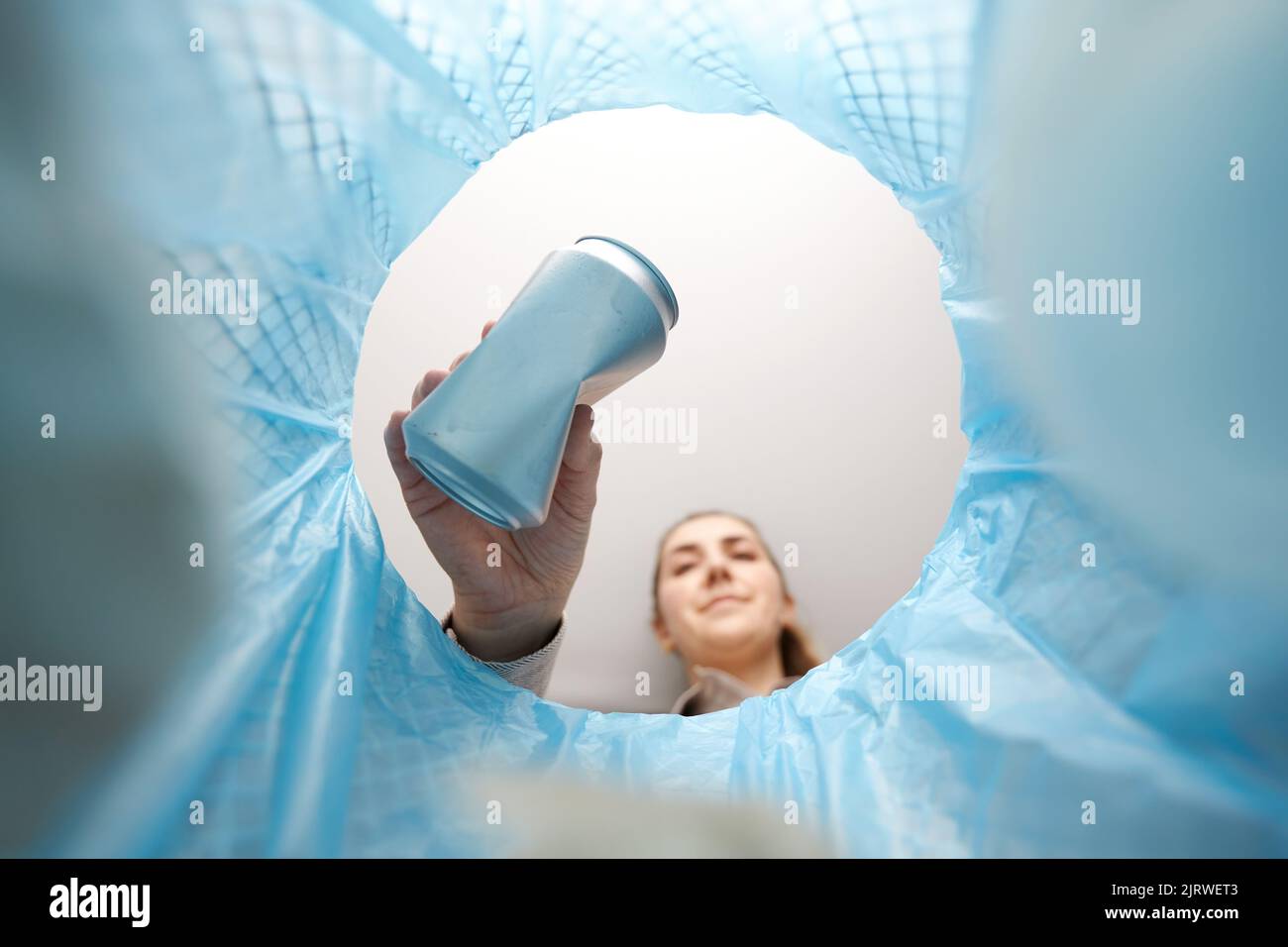 Frau wirft Blechdosen in den Abfalleimer Stockfoto