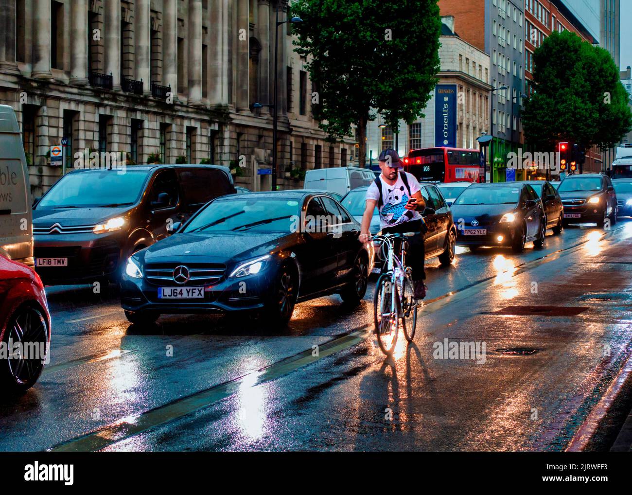 London Traffic,Jam,Euston Road,Raining,Cycliste,on Mobile,No Lights,Dusk,London,England Stockfoto