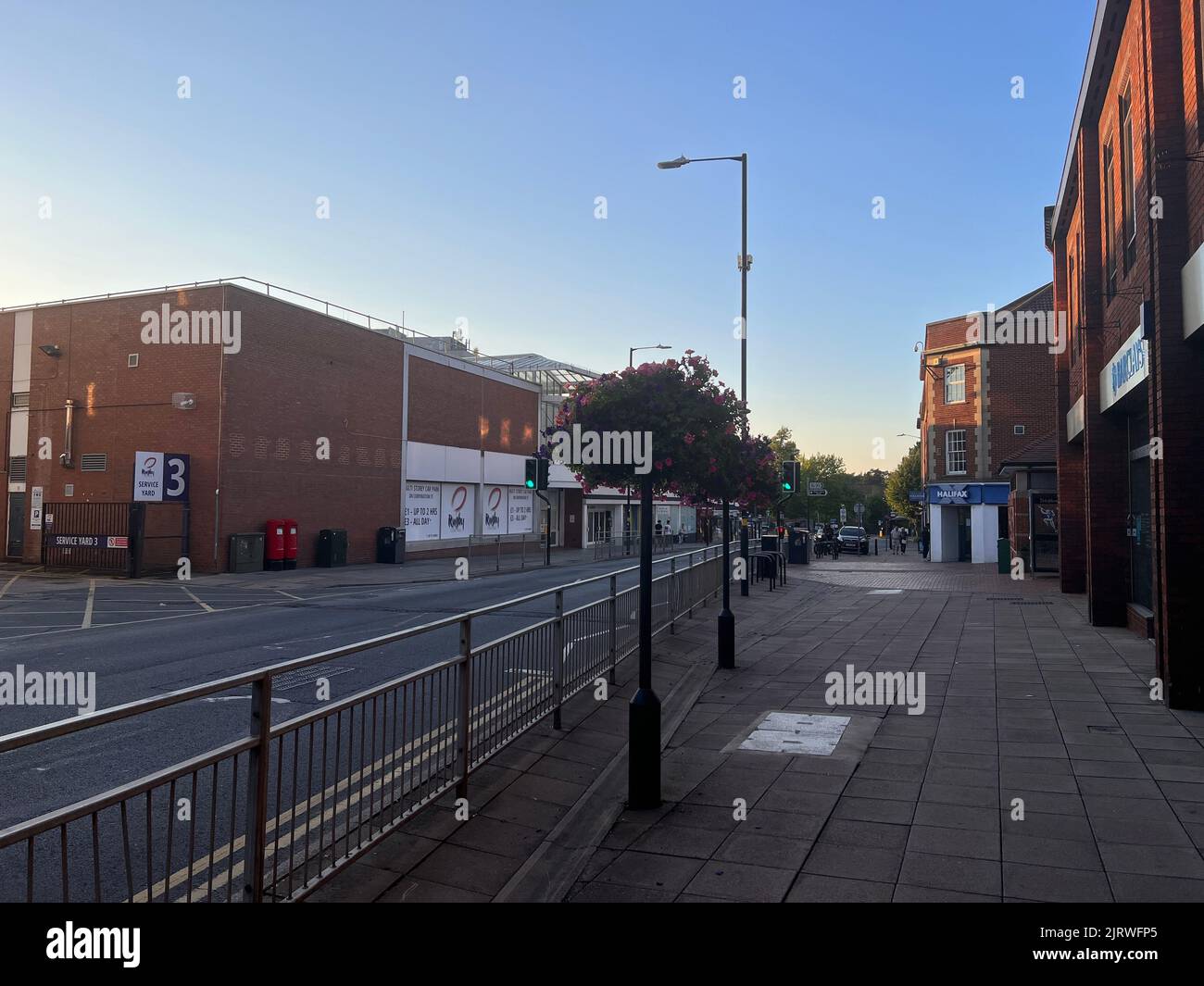 Eine Straße im Stadtzentrum von Rugby mit Rosen und Gebäuden in mittlerer Höhe tagsüber Stockfoto