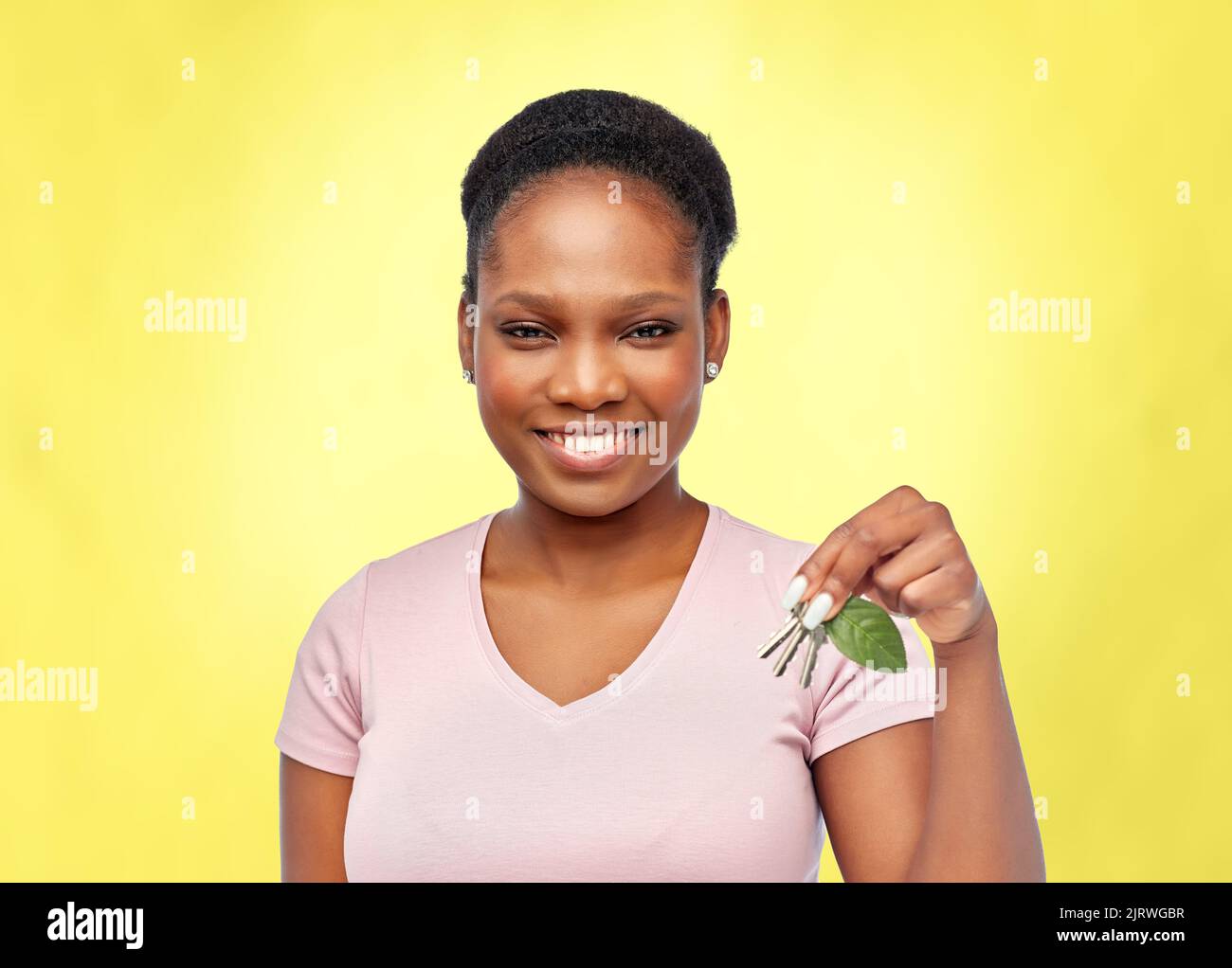 afrikanische Frau mit grünem Blatt und Hausschlüssel Stockfoto