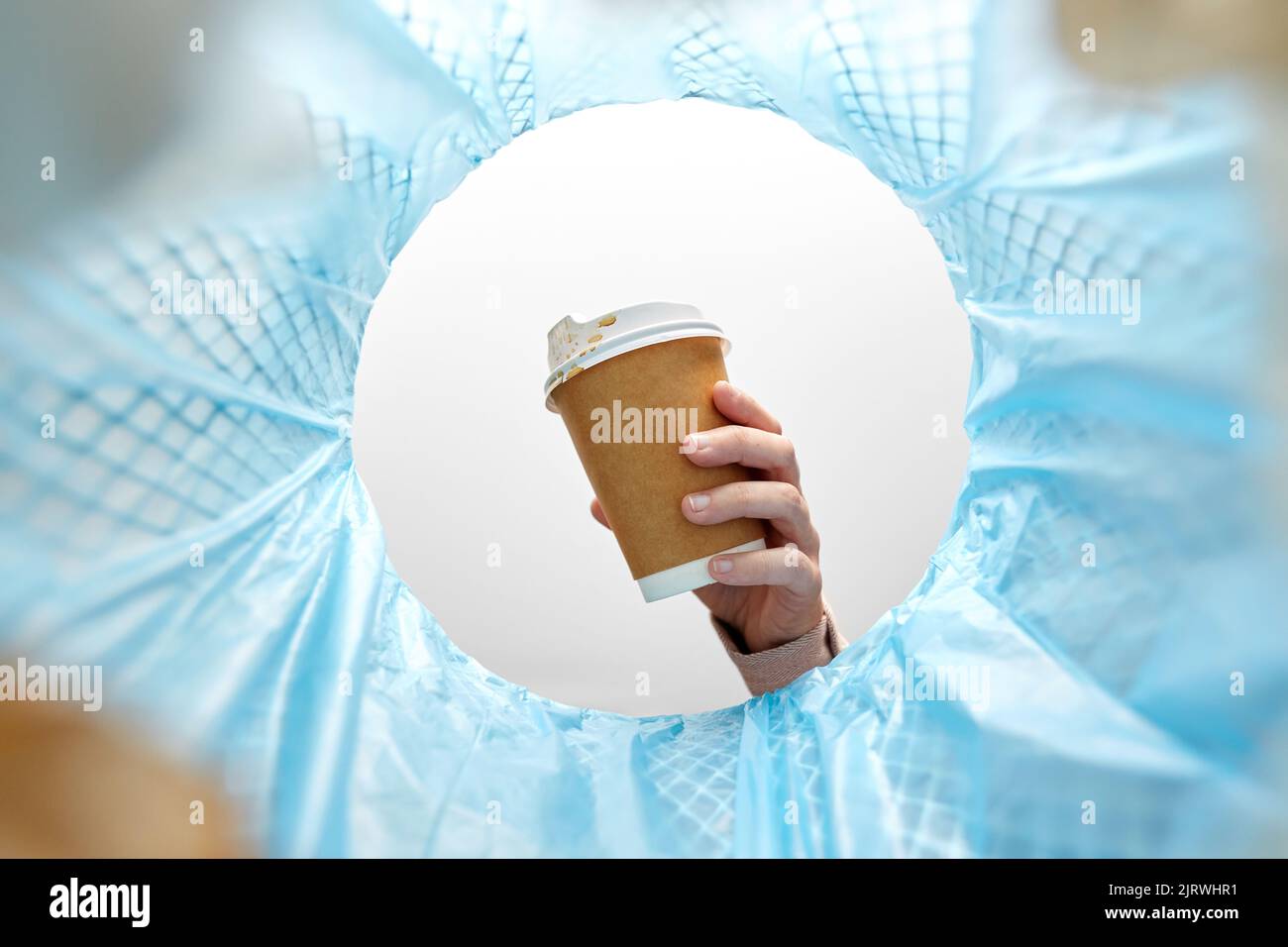 Kaffeebecher mit der Hand in den Mülleimer werfen Stockfoto
