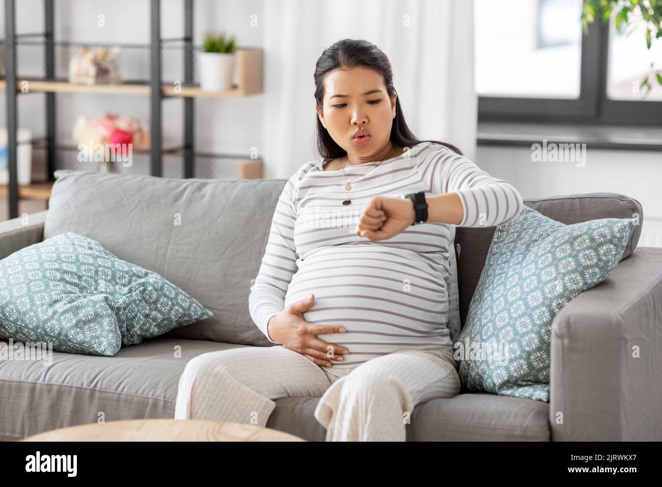 Schwanger Frau mit Wehen Kontraktionen zu Hause Stockfoto