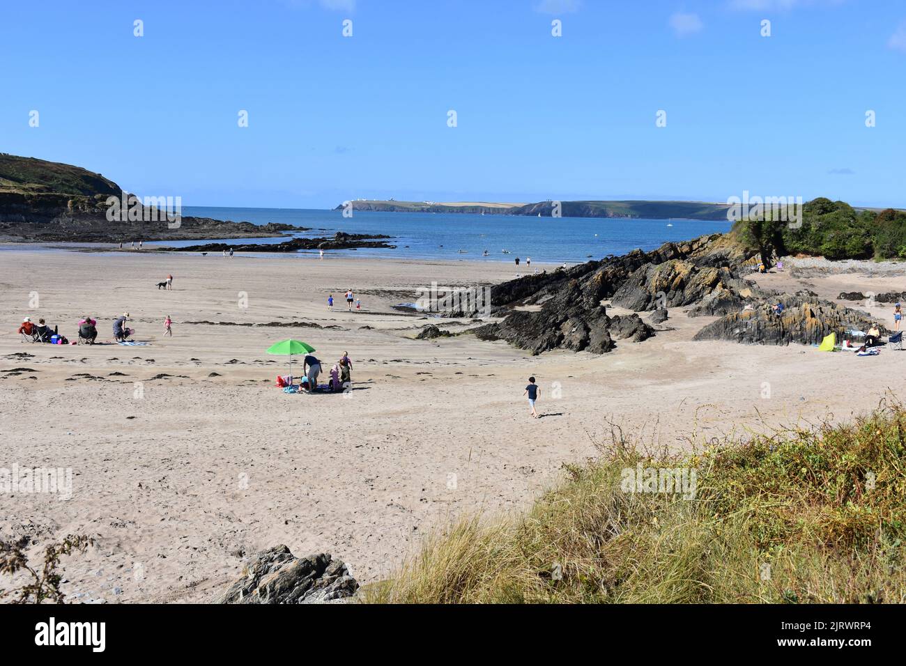 Urlauber, die West Angle Bay, Pembrokeshire, Wales, genießen Stockfoto