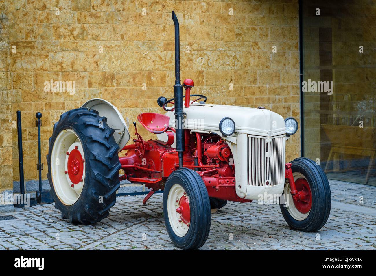 Eine Nahaufnahme eines rot-weißen Oldtimer-Traktors auf dem Display Stockfoto
