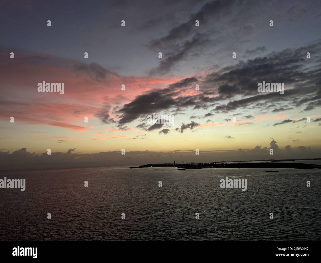 Der orange, rosa und blaue Sonnenaufgang auf den Berry Islands, Bahamas. Stockfoto