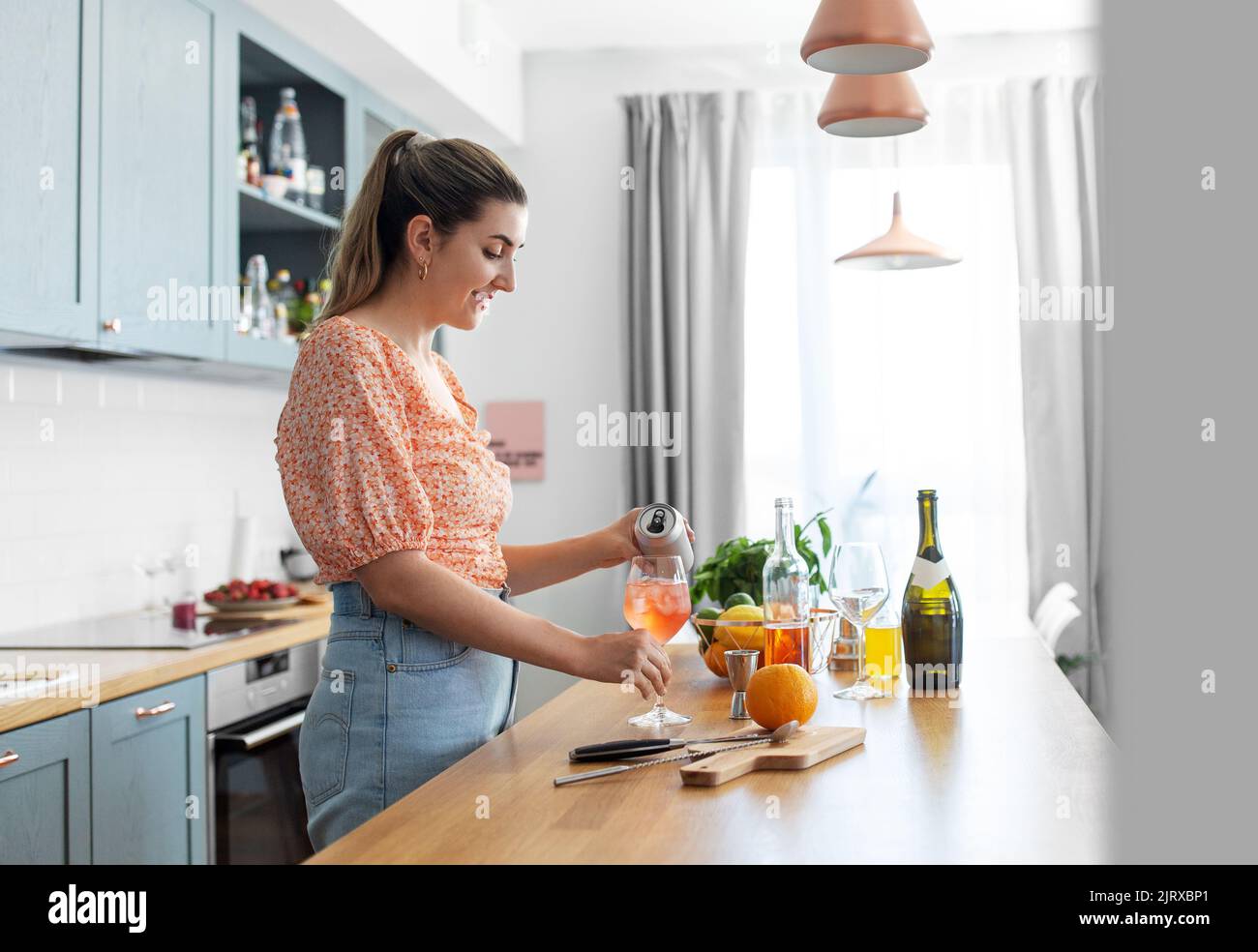 Frau, die in der Küche zu Hause Cocktailgetränke zubereitet Stockfoto