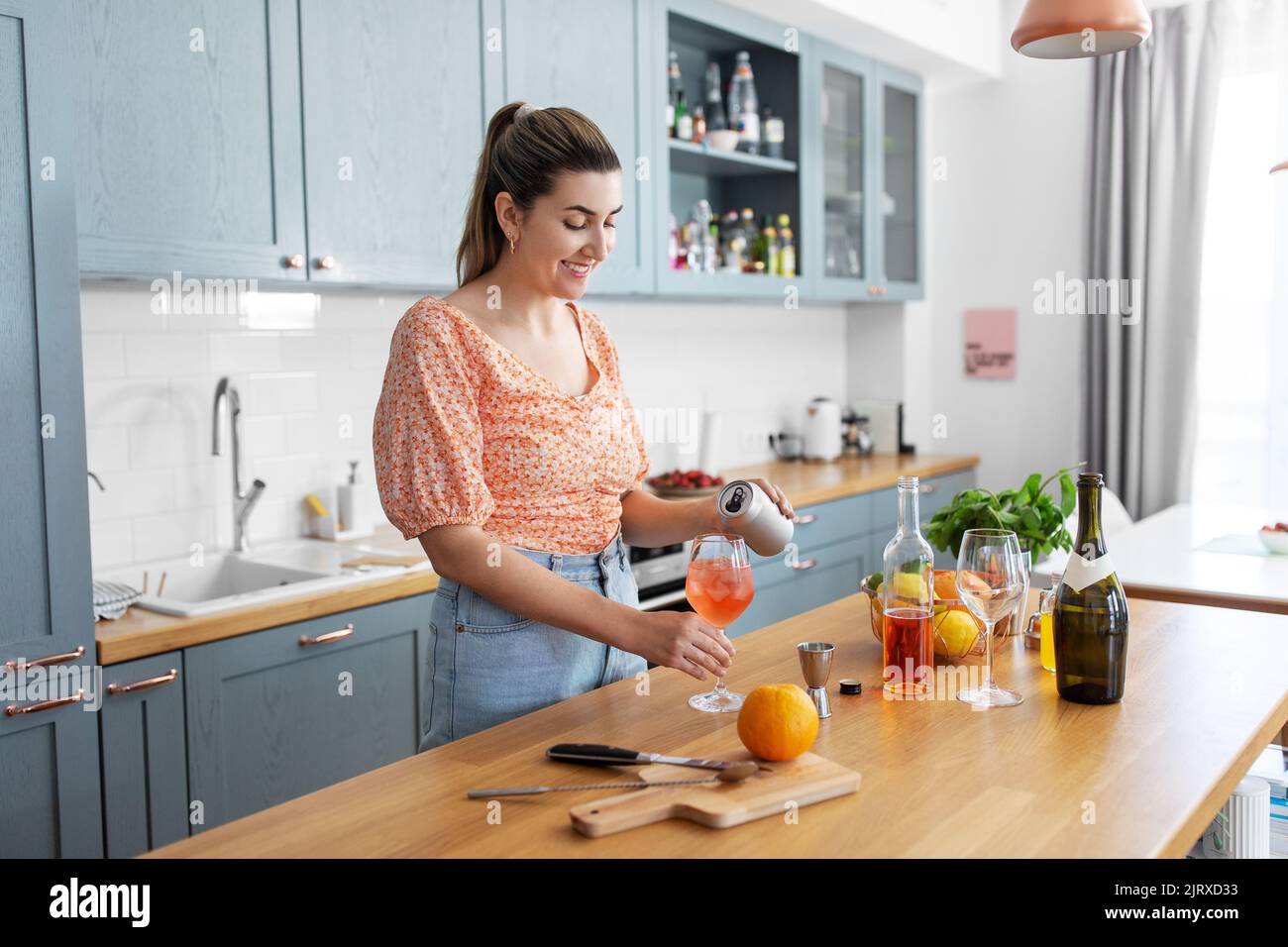 Frau, die in der Küche zu Hause Cocktailgetränke zubereitet Stockfoto
