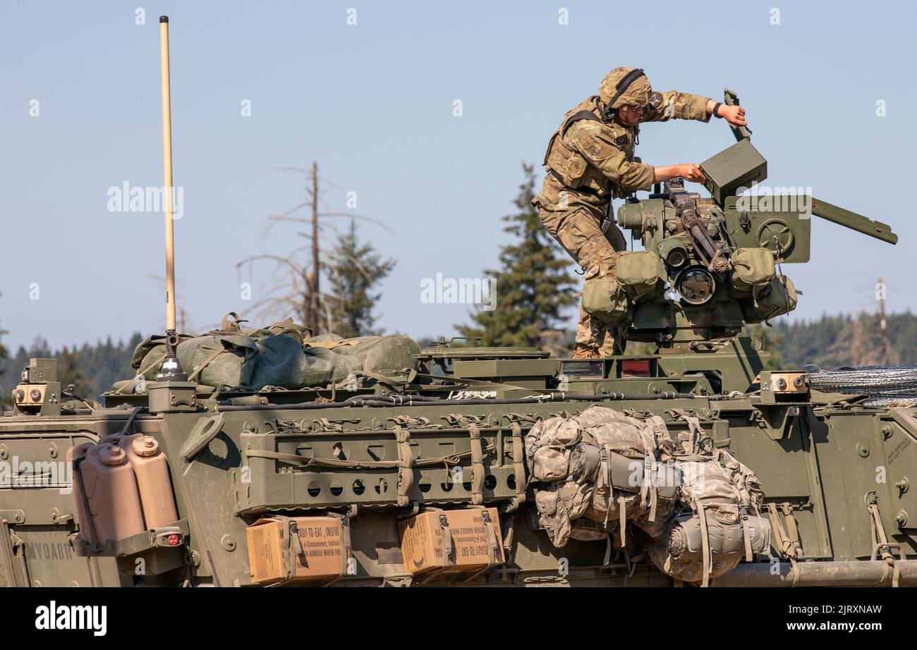 Ein Soldat von 3. Platoon, Blackhorse Company, 2-3 Infantry Regiment, 1-2 Stryker Brigade Combat Team lädt das montierte Maschinengewehr des Kalibers .50 auf sein gepanzertes Stryker Fahrzeug während einer Bewegung-zu-Kontakt-städtischen Razzia Übung auf der Joint Base Lewis-McChord, Washington, 24. August 2022. Die Übung war Teil einer zweitägigen Demonstrationsveranstaltung, die vom Program Executive Office of Ground Combat Systems veranstaltet wurde, mit dem Ziel, das Feedback der Soldaten in die Entwicklung neuer militärischer Kampftechnologien zu integrieren. (USA Armee-Foto von SPC. Chandler Coats, 5. Mobile Public Affairs Detachment) Stockfoto