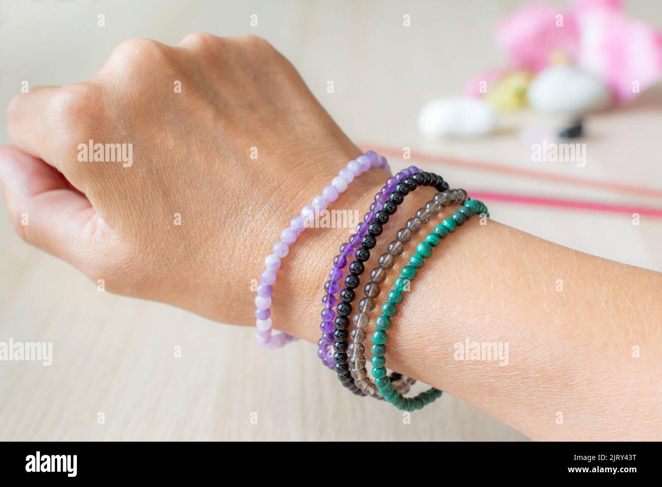 Lithotherapie. Sortiment an Armbändern aus Stein. Lepidolit, Amethyst, schwarzer Turmalin, Rauchquarz und Malachit. Stockfoto