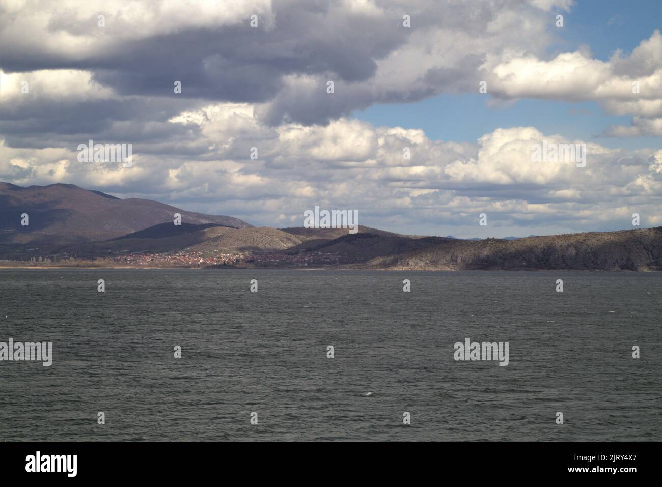 Der Vegoritida-See unter wolkigen Himmel mit Klippen im Hintergrund Stockfoto