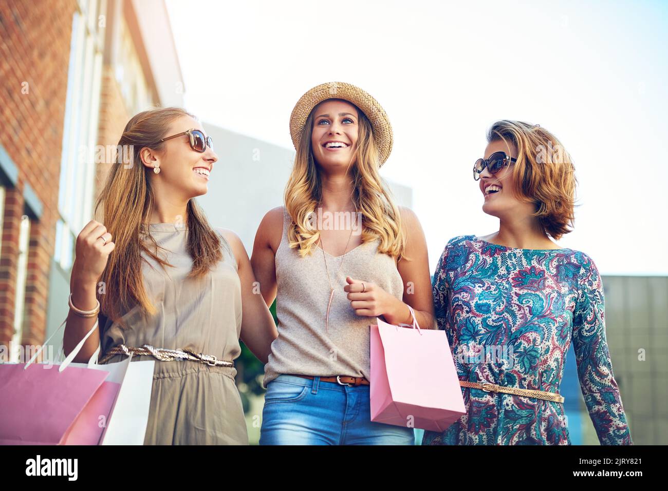 Drei junge Freundinnen, die im Stadtzentrum einkaufen. Stockfoto