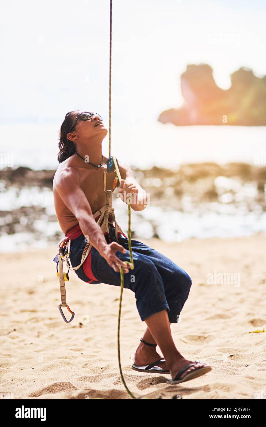 Leben auf der extremen Seite. Ein junger Mann, der an einem sonnigen Tag einen Berg besteigen wird. Stockfoto