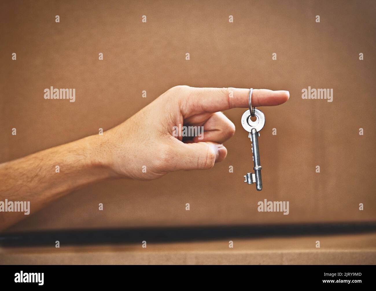 Der Schlüssel zu seinem Traumhaus. Eine unverkennbare mans-Hand, die den Schlüssel zu seinem neuen Zuhause hält. Stockfoto