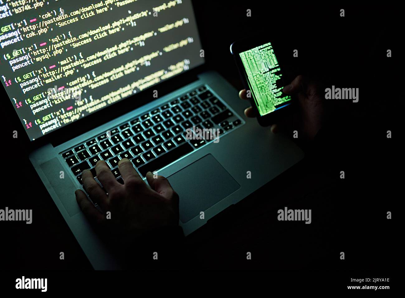 Kein Code ist unknackbar, ein nicht identifizierbarer Hacker, der spät in der Nacht einen Laptop benutzt. Stockfoto