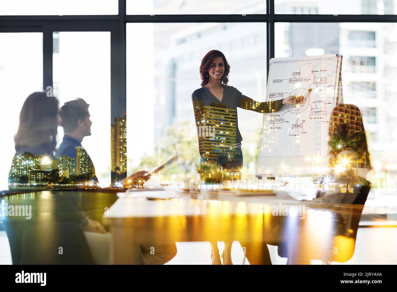 Hart arbeiten, um an der Spitze des Erfolgs zu bleiben. Mehrfachaufnahme eines Geschäftstreffens eines Unternehmens, das über einem Stadtbild überlagert ist. Stockfoto