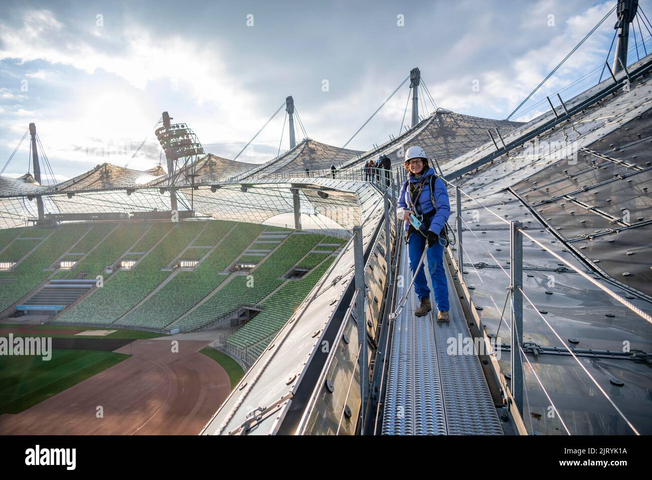 Frau mit Sicherheitsausrüstung auf dem Zeltdach des Olympiastadions, Zeltdachtour im Olympiastadion, Olympiastadion, Olympiapark, München, Bayern Stockfoto