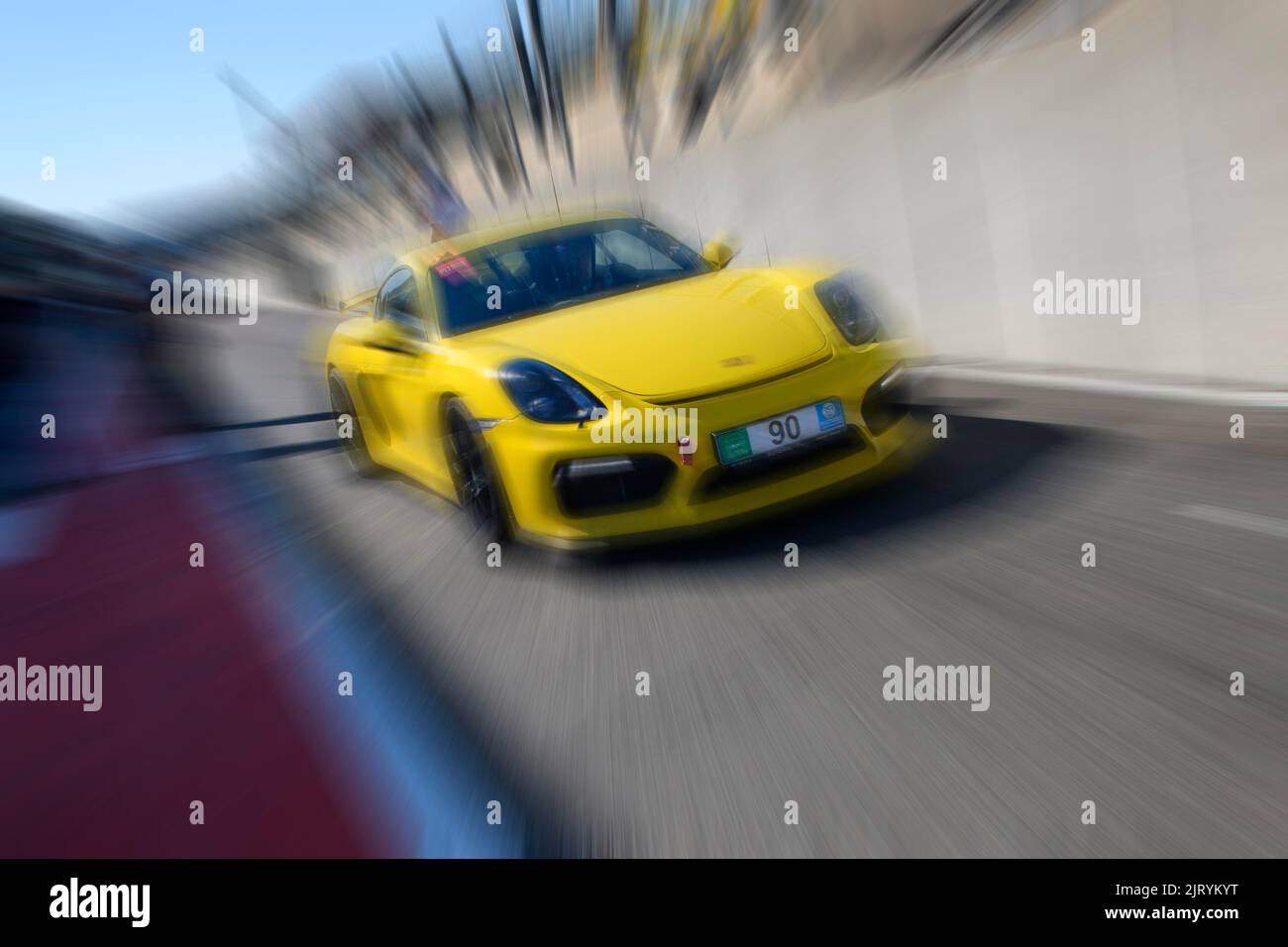 Dynamisches Foto mit Zoom-Effekt von Sportwagen-Rennwagen gelb Porsche Cayman GT4 Verlassen der Boxengasse, FIA Formel 1 Strecke, Circuit de Spa Stockfoto