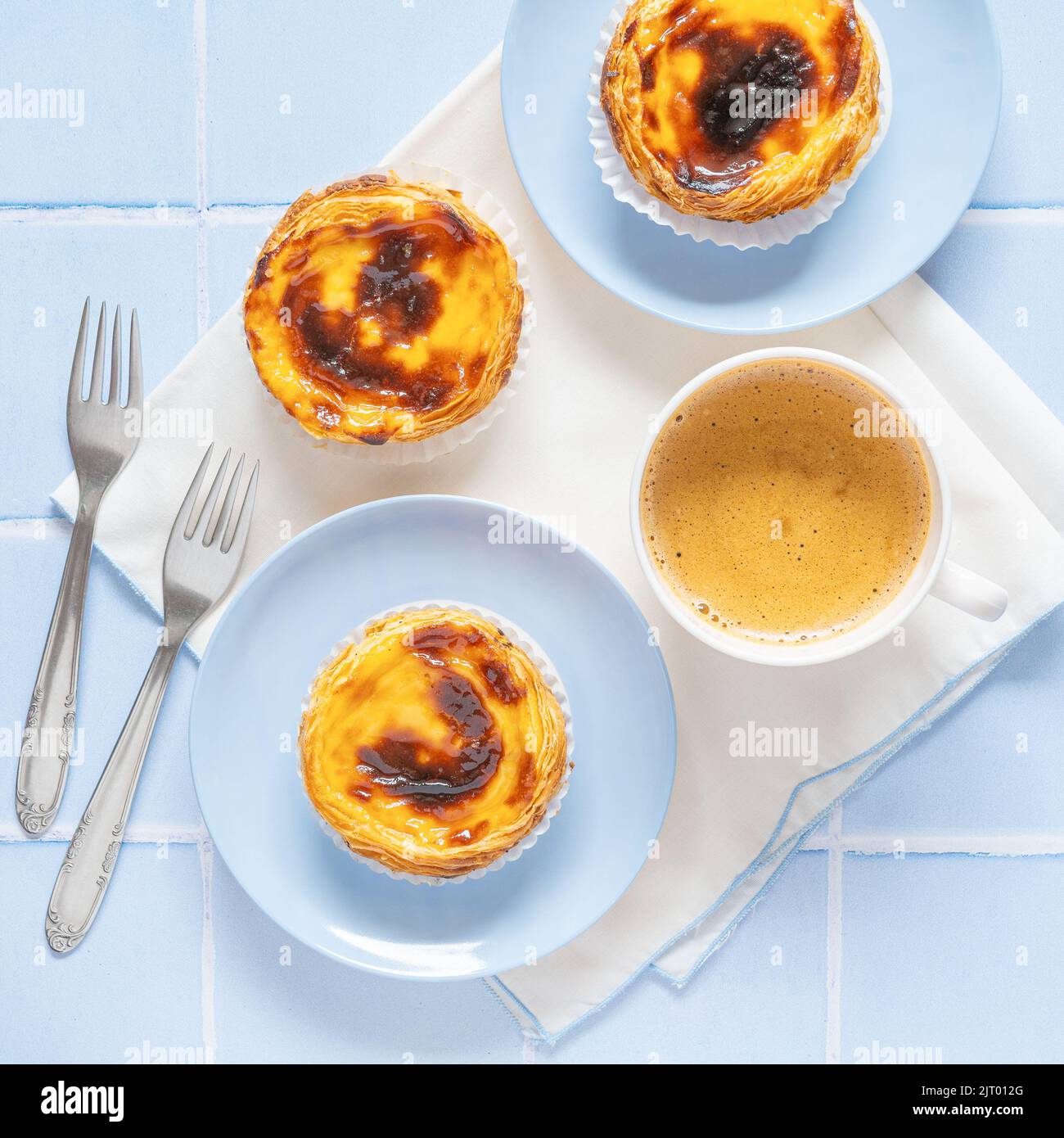 Portugiesisches Dessert Pastel de nata mit Kaffee auf blauen Fliesen Stockfoto