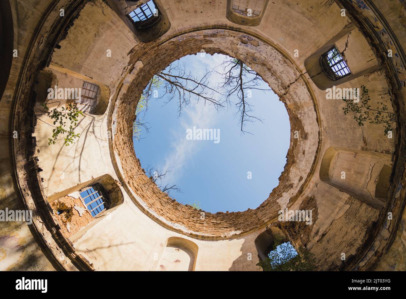 Blauer Himmel durch alten beschädigten Turm mit Fenstern und ohne Dach gesehen. Ruinen der verlassenen Kirche in Lubycza Krolewska. Horizontale Aufnahme. Hochwertige Fotos Stockfoto