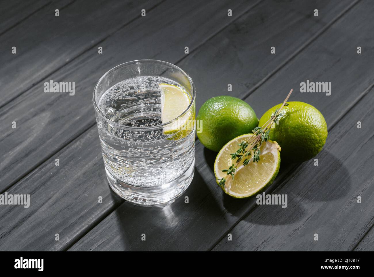 Harter Seltzer mit Kalk auf dunklem Holzhintergrund Stockfoto