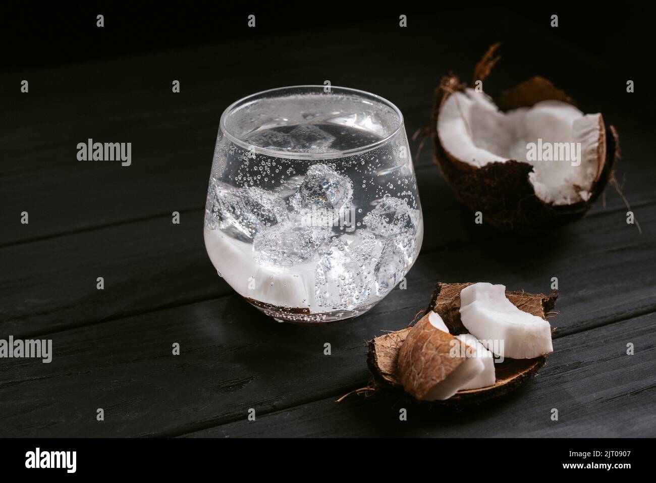 Alkoholischer Cocktail harter Seltzer mit Kokosnuss auf schwarzem Hintergrund Stockfoto