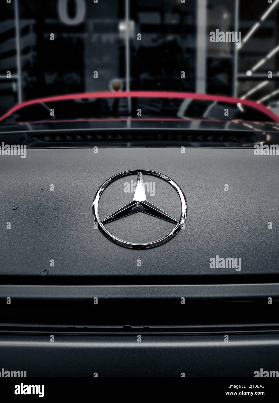 Nahaufnahme eines silbernen Mercedes-Benz-Logos auf einem Auto Stockfoto