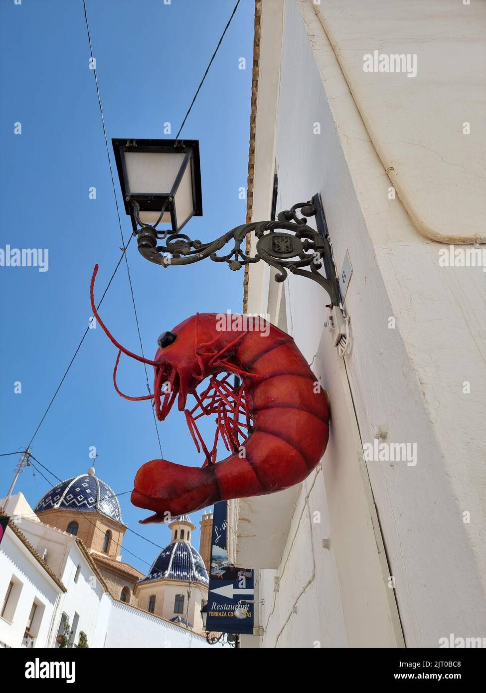 Eine vertikale Aufnahme eines roten Hummerzeichens an der Wand in Altea Stockfoto