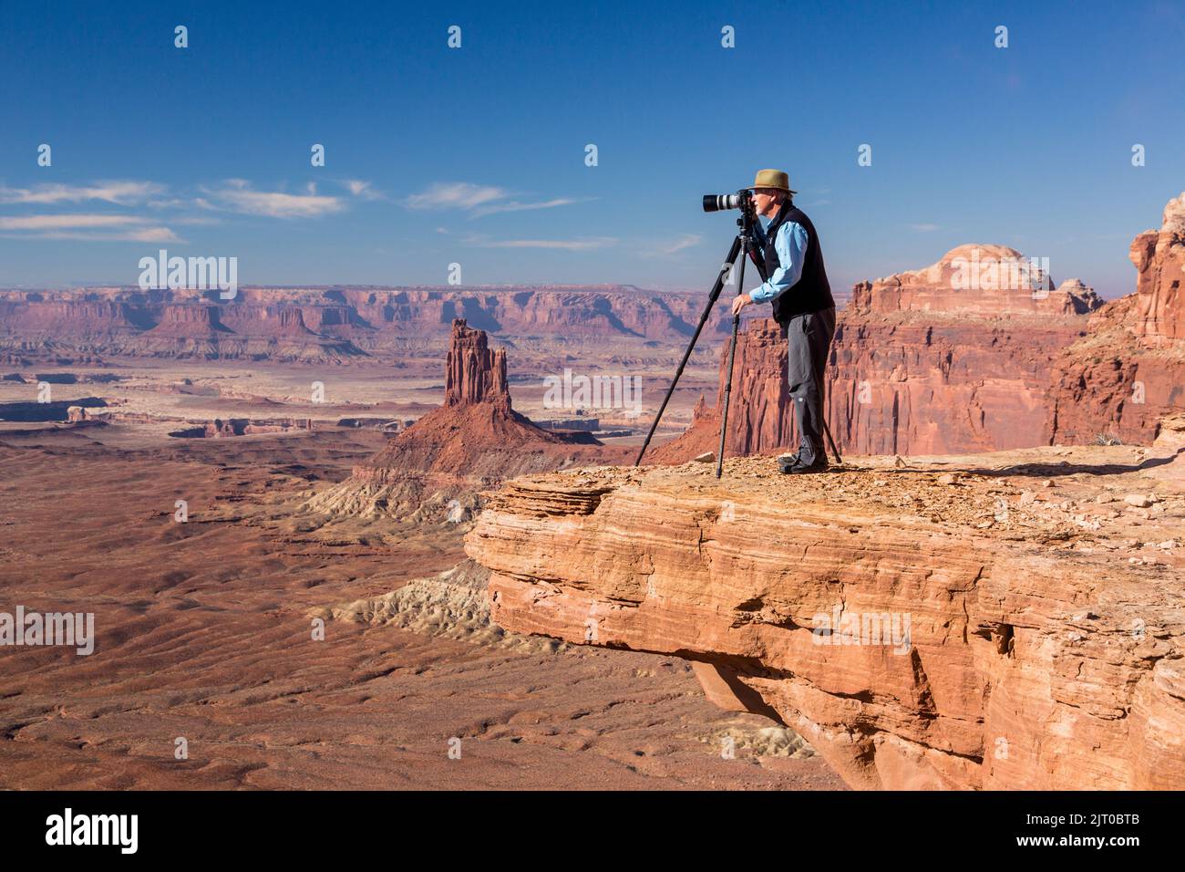 Ein Landschaftsfotograf, der ein Bild von einem überhängenden Felsen im Canyonlands National Park in der Nähe von Moab, Utah, macht. Stockfoto