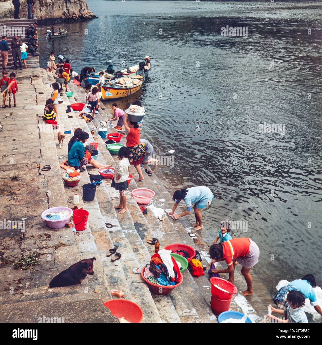 PORTUGAL - PORTO - 1970. Frauen und Kinder waschen ihre Kleidung im Fluss Douro an der Küste von Cais da Ribeira im Stadtteil Ribeira von Porto, N Stockfoto
